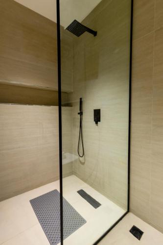 a shower with a glass door in a bathroom at 2 bedroom Atrium apartment in Gwarinpa