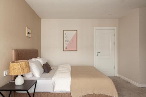 a bedroom with a bed and a table with a lamp at 2 bedroom Atrium apartment in Gwarinpa