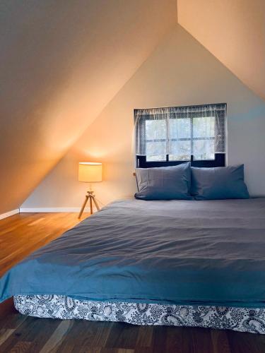 a bedroom with a large bed with a window at Atpūtas vieta Kannas in Tropmači