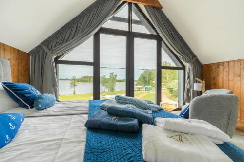 a bedroom with a bed with blue pillows and a window at "Wioska Wakacyjna Glamila" Mazury, nad jeziorem, podgrzewany basen, Glamping i domki rodzinne in Sterławki Wielkie