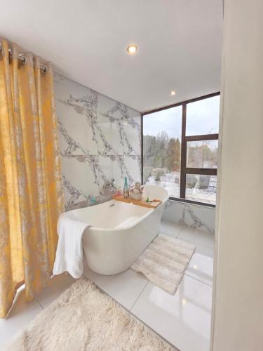 a bathroom with a tub and a window at Sbukosezwe guest house in Johannesburg