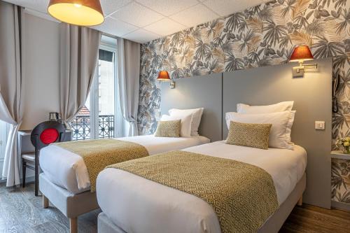 a hotel room with two beds and a window at Splendid Hôtel in Paris