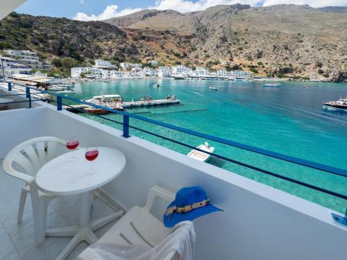 a balcony with a table and chairs and a view of the water at Sifis in Loutro