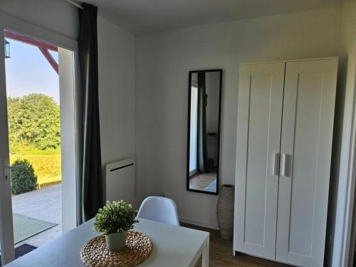 a living room with a table and a mirror at Chambre avec vue in Villefranque