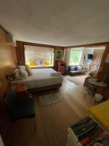 a bedroom with a large bed and a living room at Casa Refugio Relajante in Pirque