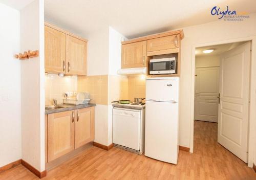 a kitchen with a white refrigerator and a microwave at Olydea les Bottieres - Saint-Pancrace in Saint-Pancrace