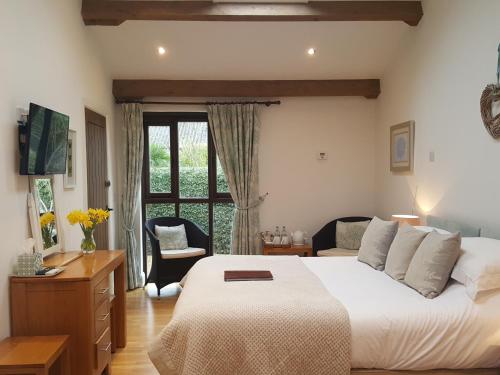 una camera da letto con un grande letto bianco e una finestra di Lockgate Dairy a Chichester