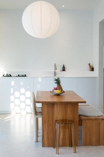 a kitchen with a wooden table with a pineapple on it at Matahari House in Nusa Lembongan