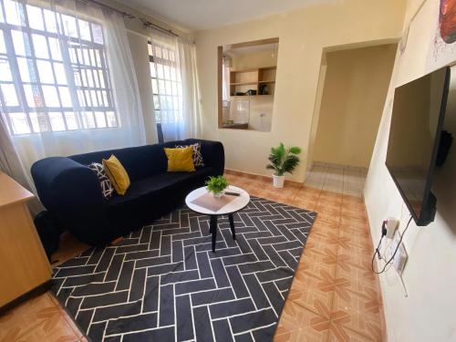 ein Wohnzimmer mit Sofa und Tisch in der Unterkunft Quiet Comforts in Embu