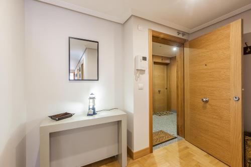a bathroom with a white counter and a wooden door at Ardantza Bidea - baskeyrentals in Zumaia