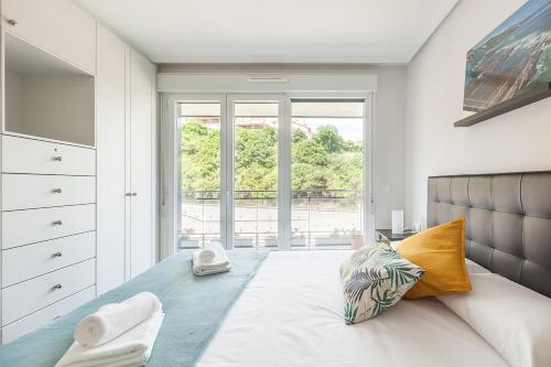 a bedroom with a bed and a large window at Ardantza Bidea - baskeyrentals in Zumaia