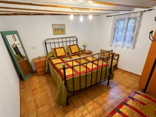 a bedroom with a bed and a mirror in it at Cortijo Mainacio in Siles