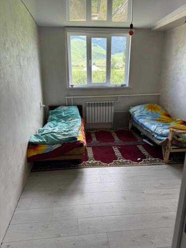 two beds in a room with a window at Altyn-Bulak in Kemin