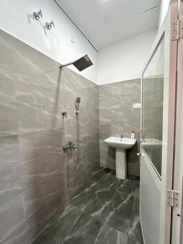 a bathroom with a shower and a sink at JB Vin Hotel in Point Pedro