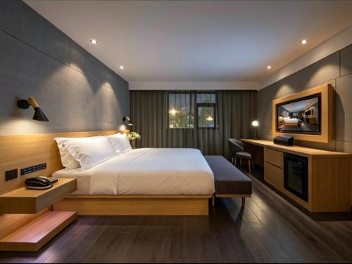a hotel room with a large bed and a desk at Orange Hotel Beijing Shangdi Huandao in Beijing