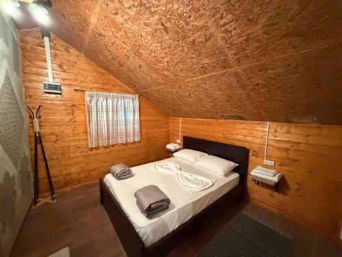 a bedroom with a bed in a wooden room at Blue Eye Villas in Sarandë