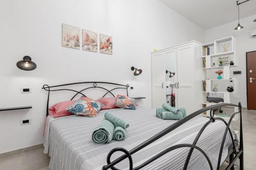 a bedroom with a bed with pink and blue pillows at Appartamenti Corallo e Conchiglia in Olbia