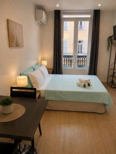 a bedroom with a bed and a large window at Résidence Appartement Adonis in Nice