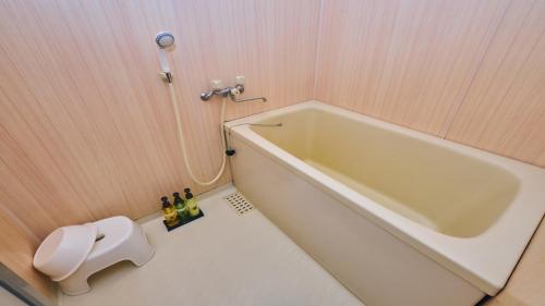 a bathroom with a bath tub in a room at Onyado Satsuki in Tamana