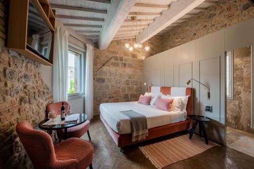 a bedroom with a bed and a table and chairs at Locanda dei Logi in San Gimignano