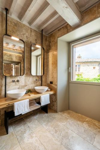 two sinks in a bathroom with a window at Locanda dei Logi in San Gimignano