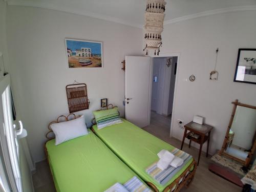 a bedroom with a green bed in a room at boundless horizon potidea in Nea Potidaea