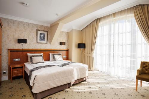 a bedroom with a large bed and a large window at Zamek Topacz in Wrocław