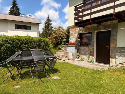 a table and chairs in a yard next to a house at Chalupa 387 in Harrachov