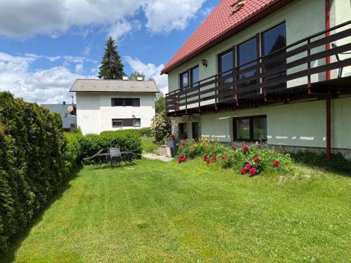 a house with a yard with flowers and a building at Chalupa 387 in Harrachov