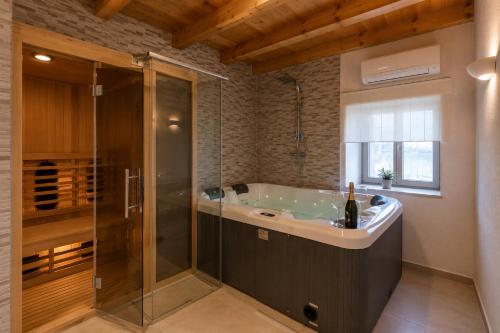 a bathroom with a tub and a glass shower at Residence Panorama in Buzet