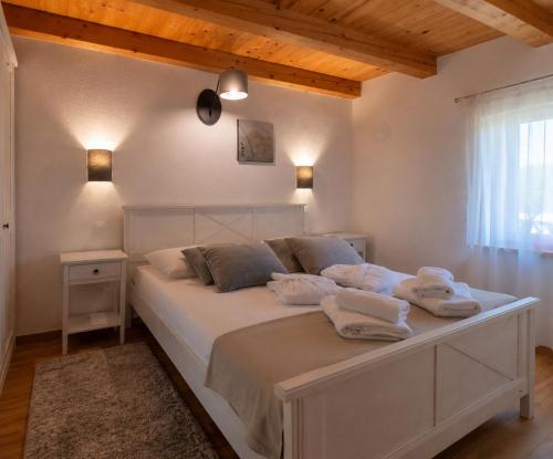 a bedroom with a white bed with towels on it at Residence Panorama in Buzet