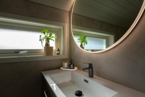 a bathroom with a sink and a mirror at Jølstraholmen Landskapshotell in Vassenden