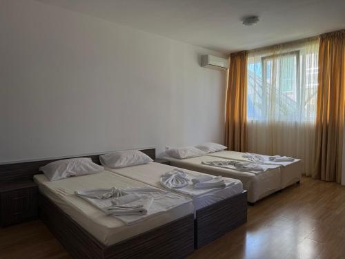 two beds sitting next to each other in a room at Guest House ASK in Primorsko