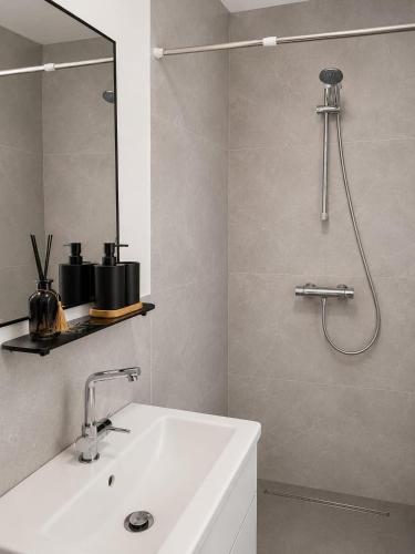 a bathroom with a white sink and a shower at Plekkenpolhof in Enschede