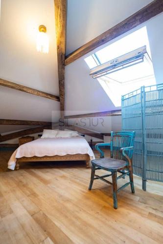 a bedroom with a bed and a blue chair at Sol By Silastur in Villaviciosa