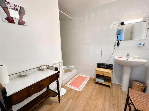 a bathroom with a sink and a bath tub next to a toilet at La maison boîte à gâteaux in Lapalme