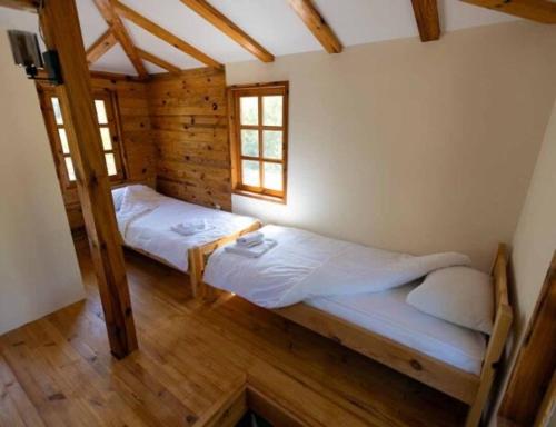 a bedroom with two beds in a wooden house at Tara Rafting Resort in Foča