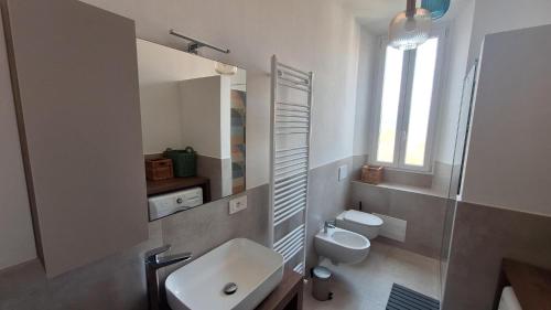 a white bathroom with a sink and a toilet at Casa Tatta - Luino centro in Luino