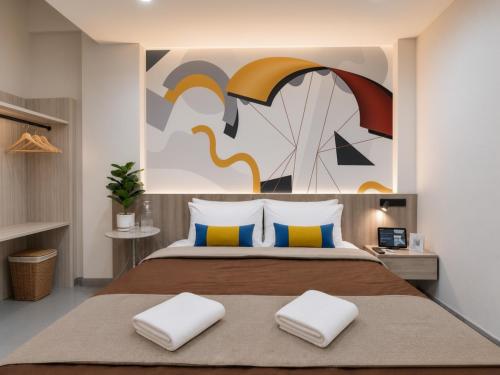 a bedroom with a bed with a painting on the wall at เดย์ อินน์ บาย วินด์แฮม ระยอง อู่ตะเภา in Ban Chang
