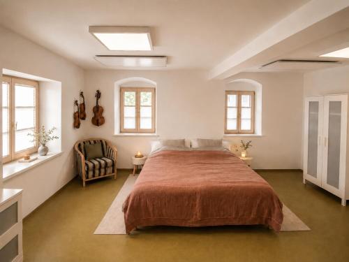 a bedroom with a large bed and a chair at Geigenhof in Neudorf bei Ilz