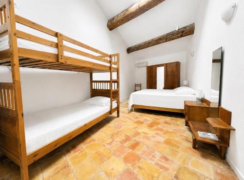 a bedroom with two bunk beds and a desk at La maison boîte à gâteaux in Lapalme