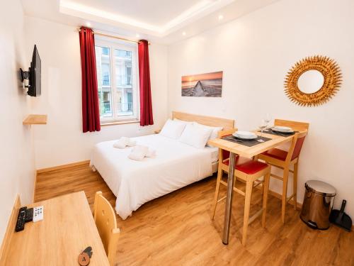 a bedroom with a bed and a desk and a table at Residence Akantha in Nice