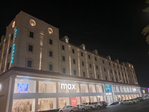 a large building with cars parked in front of it at شقق أعلي الثناء المخدومة -ELI ALTHANA Serviced Apartments in Yanbu