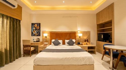 a hotel room with a bed and a desk at Soho Suites in Bedla