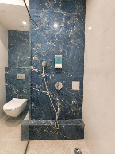 a bathroom with a toilet and a blue marble wall at Soho Suites in Bedla