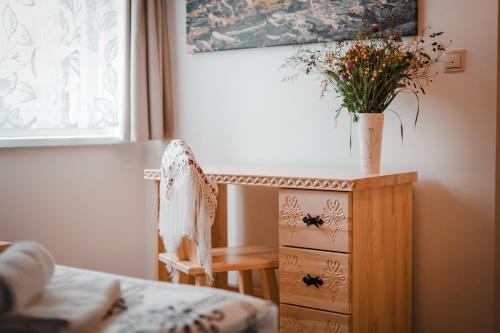 a bedroom with a dresser and a vase with flowers on it at U Hani in Bańska Wyżna