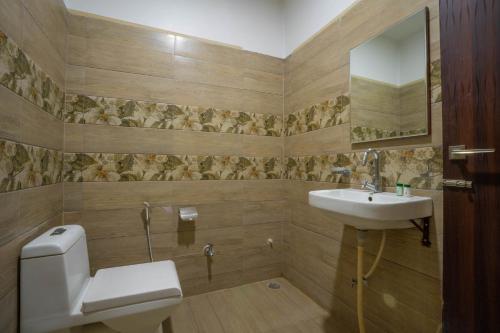 a bathroom with a toilet and a sink at Hotel Kiaara in Varanasi