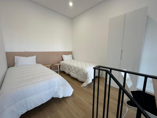 a bedroom with two beds and a balcony at AlvaLoft Barreiro in Barreiro