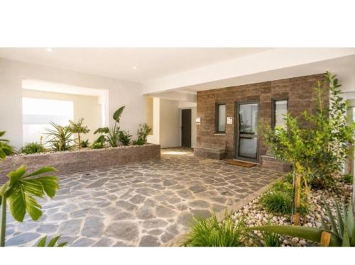 a house with a stone courtyard with plants at Markella's apartment Karystos in Karistos