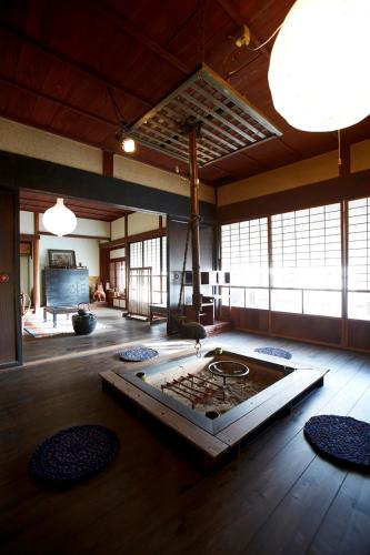 a large room with a living room with a fireplace at ゲストハウス やまんなか in Kamida
